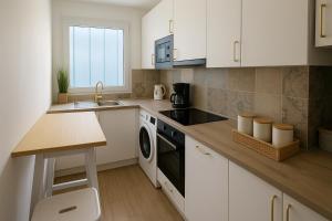 a kitchen with white cabinets and a sink and a dishwasher at Magic Disney Penthouse, 11P, Terrasse, Parking in Chessy