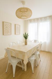 a dining room table with white chairs and a chandelier at Magic Disney Penthouse, 11P, Terrasse, Parking in Chessy +8 photos