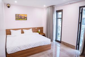 a bedroom with a white bed and a large window at Mapileng Horizon 2 - Hotel - Tour - BusTicket - Motobike Rent in Ha Giang