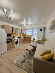 a living room and kitchen with a couch and a table at Yellow Apartment in Floreşti