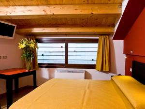 a bedroom with a yellow bed and a window at Casepicarmo Guest House in Augusta