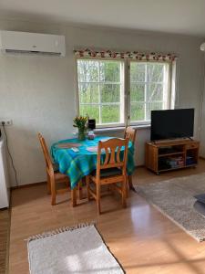 a living room with a table and chairs and a television at Сottage under the trees in Rajaküla +11 photos