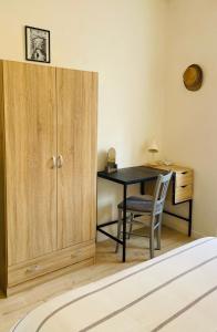 a room with a desk and a table and a cupboard at Le cocon familial in Digne-les-Bains