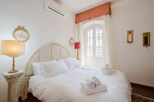 a bedroom with a white bed with towels on it at Villa Vittoria in Sorso +140 photos