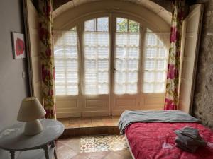 a bedroom with a bed and a large window at La Maison De La Tour Annex in La Sauvetat-du-Dropt +11 photos