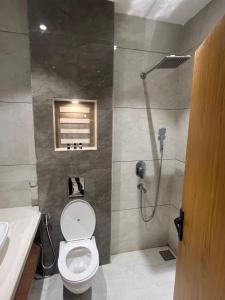 a bathroom with a toilet and a shower at Sea rock hotel in Gangānagar +17 photos
