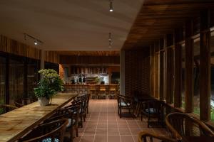a restaurant with a long wooden table and chairs at Chuồn Chuồn Retreat in Phan Thiet