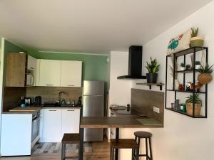a kitchen with white cabinets and a wooden table at Charment Appartement Duplex - Pornichet in Pornichet