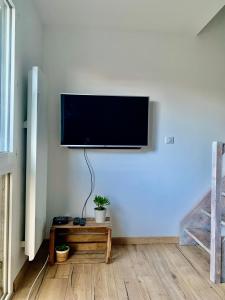 a flat screen tv hanging on a wall at Charment Appartement Duplex - Pornichet in Pornichet