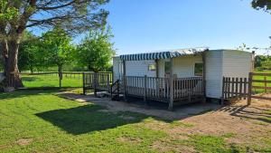 a tiny house with a porch and a fence at Le fief in Le Tablier