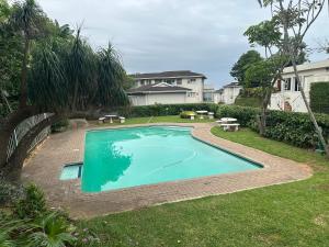 a swimming pool in the yard of a house at Mangrove Beach Estate - Mzimayi 2 in Port Shepstone