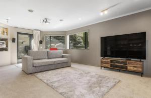 a living room with a flat screen tv and a couch at Kurupae House - Taupo Central in Taupo