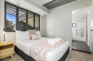 a white bedroom with a bed and a window at Kurupae House - Taupo Central in Taupo