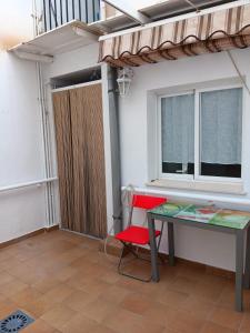 a table and a chair in a room with a window at Plaza Ayuntamiento 2 habitaciones Pondos in Linares