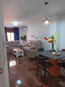 a living room with a table and a couch at Plaza Ayuntamiento 2 habitaciones Pondos in Linares