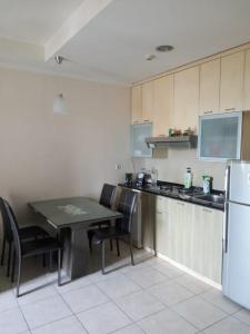 MantaakCity Home Moi Kelapa Gading Jakarta 14250的带桌子和冰箱的小厨房