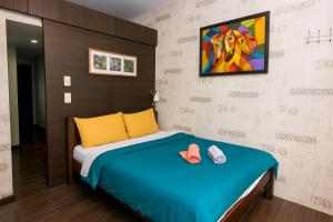 a bedroom with a bed and a painting on the wall at The Plush Pad Makati Ayala Views 300MB WiFi 1940 in Manila