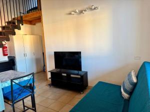 Una sala de estar con un sofá y un televisor. en Casa vacanze Le Dune, en Policoro