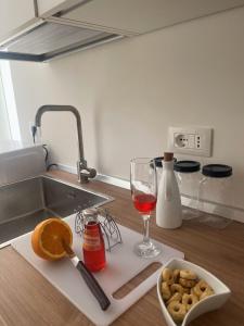 Una encimera de cocina con una copa de vino y un plato de comida. en Mariannina Apartments - Maiori, en Maiori 70 fotos más