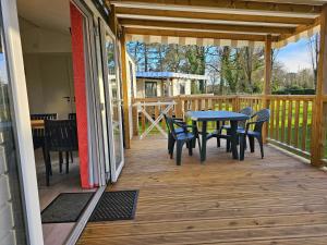 a patio with a table and chairs on a deck at Camping Les Goélands Carnac in Plouharnel