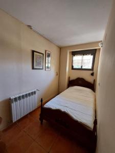 une petite chambre avec un lit et une fenêtre dans l'établissement Finca La Barrosa, à Zamora