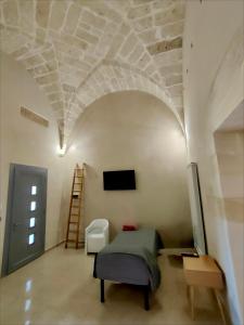 a room with a bed and a tv on a wall at I Tre Pumi in Surbo
