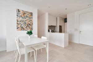 une salle à manger blanche avec une table et des chaises blanches dans l'établissement Lumi Tropicana Golf Course View, à Petaling Jaya