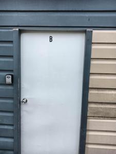 a white garage door with the letter b on it at 1 Bedroom garden chalet, 7B Salisbury Road, Rotorua in Rotorua