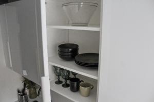 despensa de cocina con platos y cuencos en estanterías en Modern 1BR Flat - Great Location, en Riga 18 fotos más