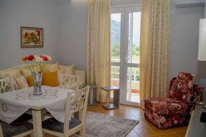 a living room with a table with a vase of flowers on it at Ana's House in Orikum