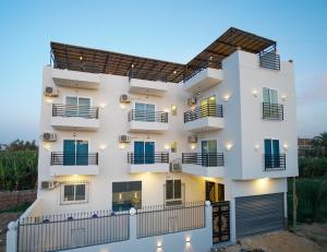 un edificio blanco con balcones y una valla en Villa Pure Luxor, en Luxor