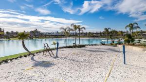 a beach with a swing in front of a body of water at Santa Rosalía Lake & Life Resort Penthouse in Torre-Pacheco