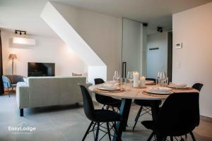 ein Esszimmer mit einem Tisch mit Stühlen und einem Sofa in der Unterkunft Nieuwe vakantiewoning met tuin dicht bij strand in Middelkerke