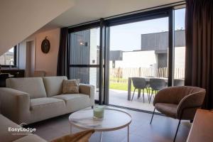 ein Wohnzimmer mit Sofa und Tisch in der Unterkunft Nieuwe vakantiewoning met tuin dicht bij strand in Middelkerke