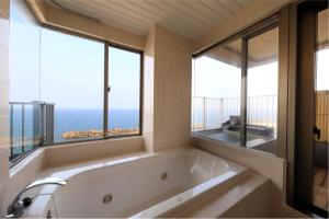 e bagno con vasca e vista sull'oceano. di Yukibou Hakusen a Yonago