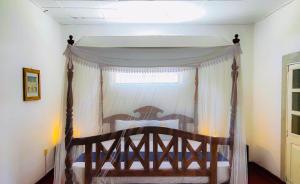 a bedroom with a wooden bed with a canopy at Enara House in Anuradhapura +9 photos