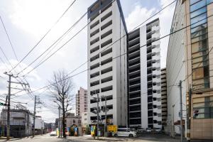 a tall white building on a city street at LIVEIL Hakataekimae in Fukuoka