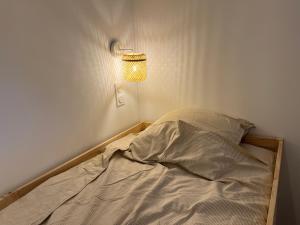 an unmade bed in a room with a lamp at Confort et évasion à l'Almanarre in Hyères