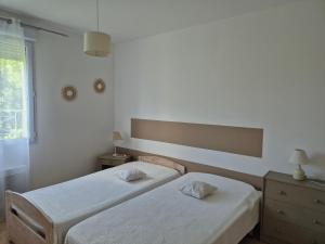 a bedroom with two beds and a window at Le Hameau des Cardenals in Salviac +35 photos