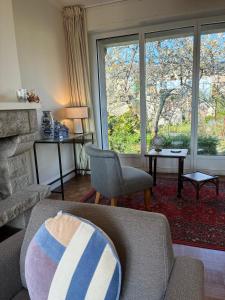 een woonkamer met een bank, een stoel en een raam bij Maison Hyper centre Dinan 2,4 ou 6 personnes in Dinan