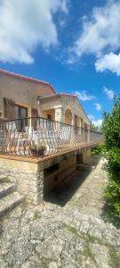 a building with a balcony on top of it at Villa Maison de campagne 04 Vacheres Luberon 3 chambres 8 personnes in Vachères