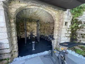una palestra con una bicicletta in un tunnel di pietra di Residence Zangirolami - Luxury Garden and Balcony Apartments a Riva del Garda Altre 45 foto