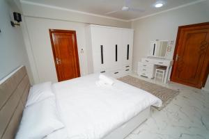 a white bedroom with a large bed and a television at Villa Pure Luxor in Luxor +18 photos