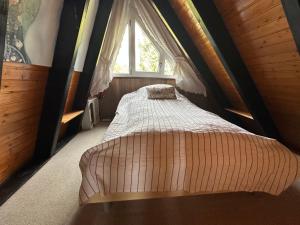 a bed in a room with a window at Ferienhaus im Feriendorf Freilingen (Eifel). in Freilingen +23 photos