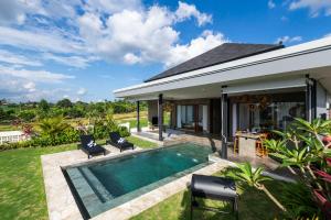 a backyard with a swimming pool and a house at Newly Built Villa - Rice Fields & Tranquil Getaway in Tumbak Bayuh