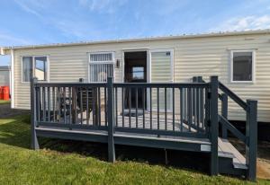 a mobile home with a deck and a railing at St Marys Light house, Caravan Rentals in Whitley Bay