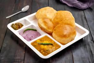a plate of food with biscuits and other foods at Silver Line Hotel - Kolkata Nr Netaji Subhash Chandra Bose International Airport with Airport Drop in Kolkata