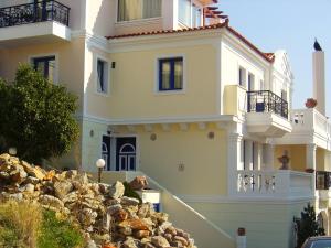 a white house with a pile of rocks in front of it at Kalimera Hotel in Poros