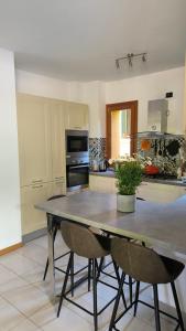 una cucina con un grande tavolo e sedie di Gloria's GARDENIA RETREAT a Como Altre 2 foto