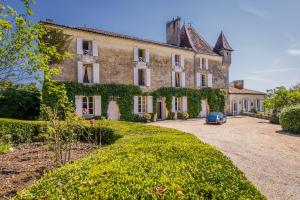 an old house with a car parked in the driveway at Chateau de la Guerinchie, beautiful 7 bedroom castle in the heart of the Dordogne in Thiviers